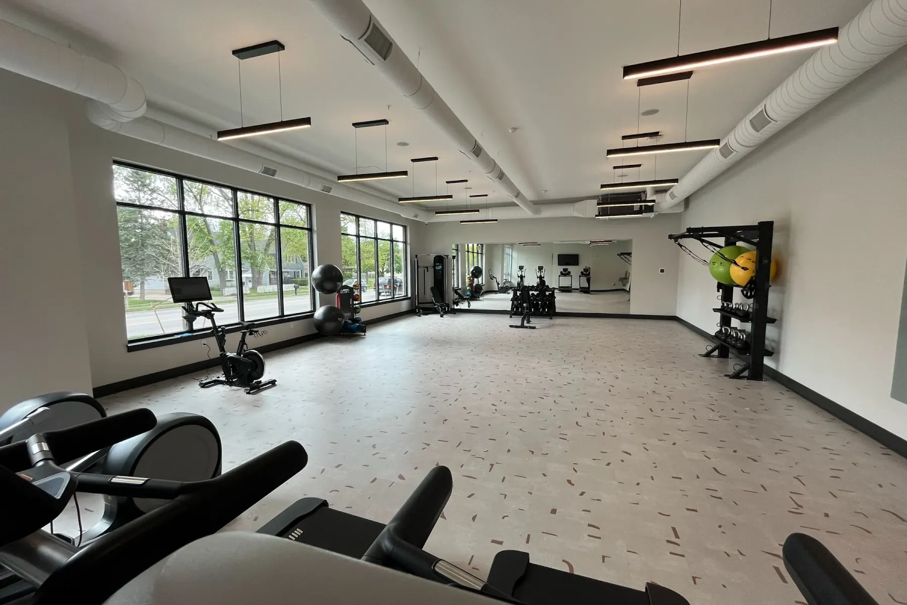 24-hour fitness center with treadmills, ellipticals, and free weights